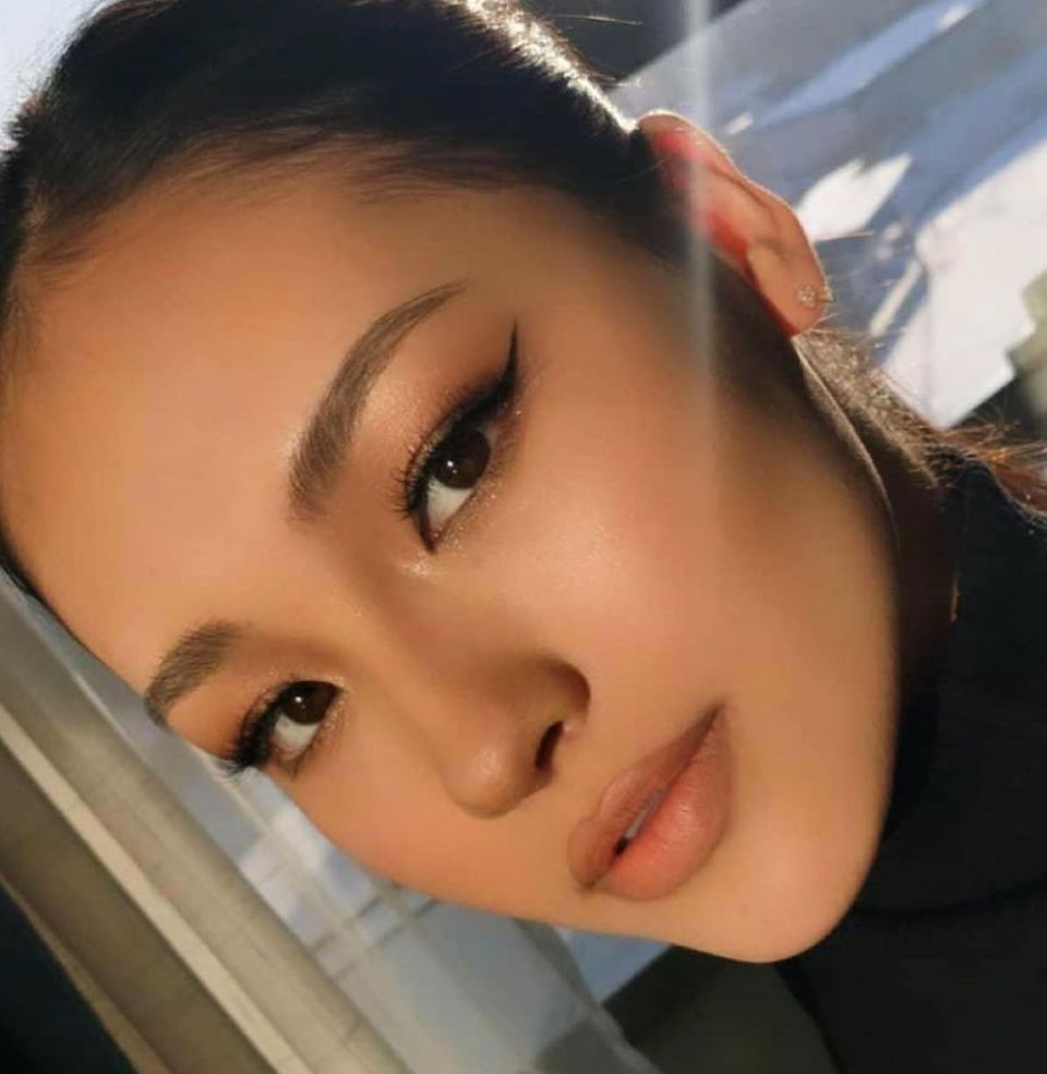 Candid close-up beside a window, soft directional natural light, neutral glam eye and glossy lip